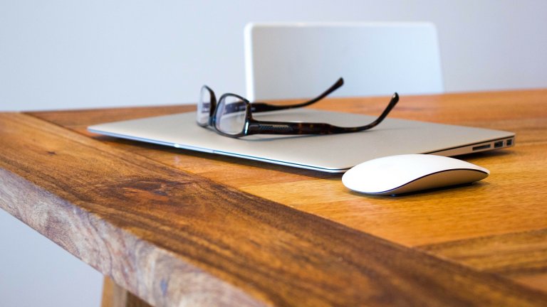 Macbook Brille und Laptop auf Tisch
