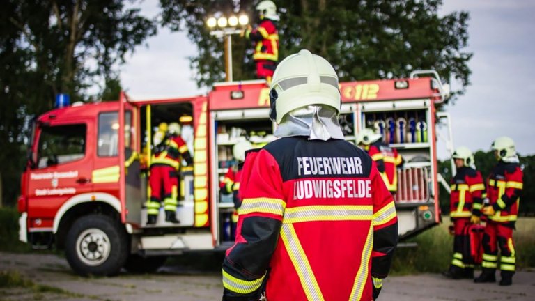 Feuerwehrmann vor Einsatzfahrzeug